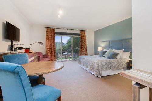 紅山南的住宿－Quattro at Mantons Creek，酒店客房设有一张床铺、一张桌子和一间卧室。