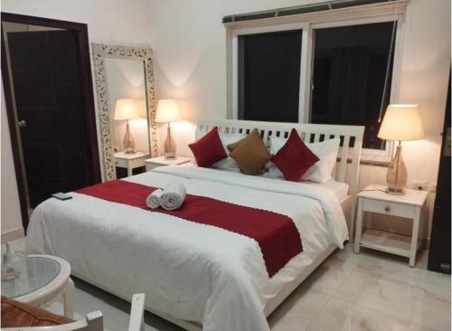 a bedroom with a large white bed with red pillows at Luxury Royal Penthouses in Bhowāli