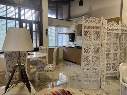 a room with a table and chairs and a kitchen at Luxury Royal Penthouses in Bhowāli