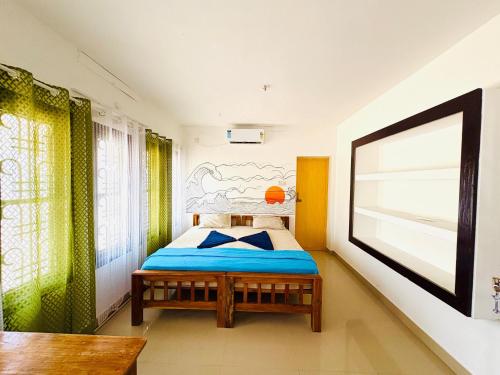 un dormitorio con una cama en una habitación en Yes Hostel Varkala - Black Beach Road, en Varkala