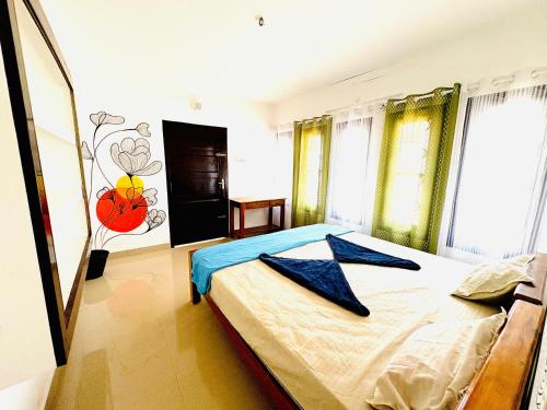 a bedroom with a bed and a painting on the wall at Yes Hostel Varkala - Black Beach Road in Varkala