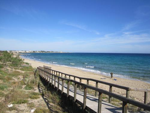a person walking on a beach near the ocean at Masseria Giustiniani in Torricella