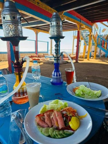 a table with two plates of food on it at New Sphinx Resort in Dahab