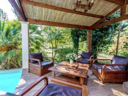 a patio with a table and chairs and a pool at Holiday Home in Le Luc with Pool & Vineyards in Le Luc