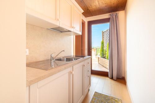 a kitchen with a sink and a large window at Agriturismo Il Follo in Valdobbiadene