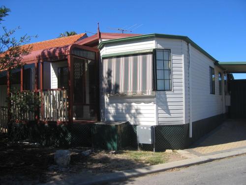 a small white house with a red roof at Fremantle Village in Fremantle