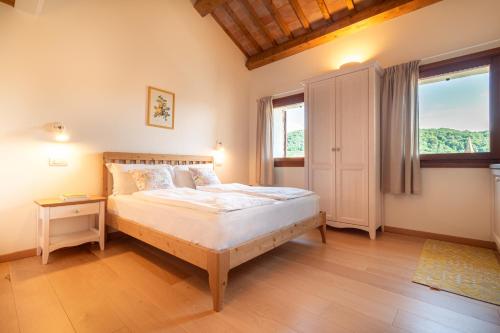 a bedroom with a bed and a large window at Agriturismo Il Follo in Valdobbiadene