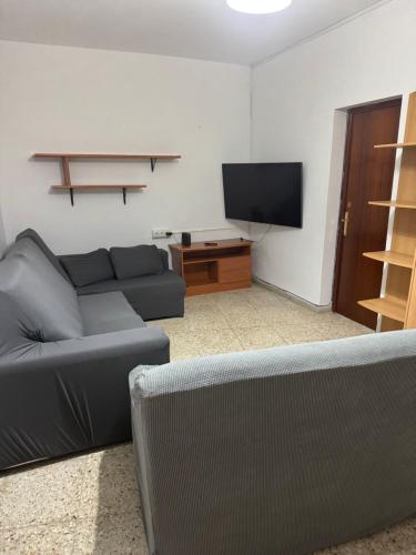 a living room with a couch and a flat screen tv at Casona Los Sidoros Ciudad de Berja in Berja