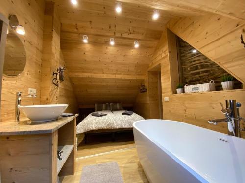 a bathroom with a tub and a sink and a bed at Holiday home in Ouren with infrared sauna in Burg-Reuland