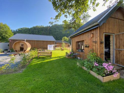 a backyard with a wooden shed and a garden at Holiday home in Ouren with infrared sauna in Burg-Reuland
