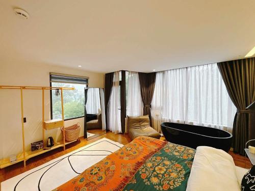 a bedroom with a bed and a chair in a room at COCO HOUSE Bùi Thị Xuân, Đà Lạt in Da Lat