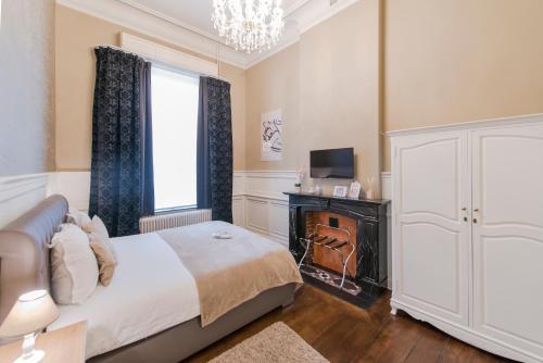 a bedroom with a bed and a window and a television at Boutique Hotel Huys van Steyns in Tongeren