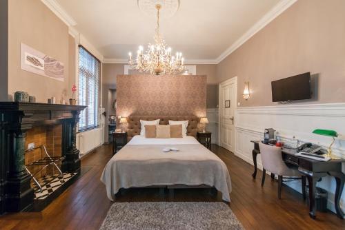 a bedroom with a bed and a desk and a chandelier at Boutique Hotel Huys van Steyns in Tongeren
