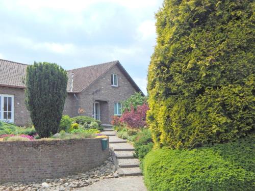a house with a garden between two large trees at Holiday Home in Sittard with Pool in Spaubeek