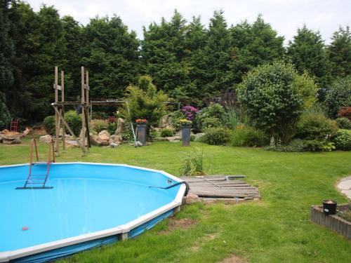 a blue swimming pool in a yard with trees at Holiday Home in Sittard with Pool in Spaubeek