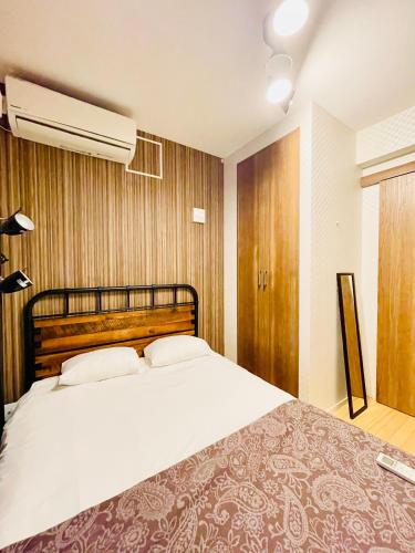 a bedroom with a large white bed and a fan at Alo BnB 1 - Near UENO, AKIHABARA, SENSOJI, TOKYO SKY TREE - Self check-in in Tokyo