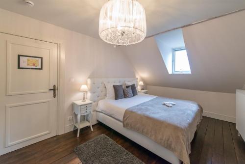 a bedroom with a large bed and a chandelier at Boutique Hotel Huys van Steyns in Tongeren