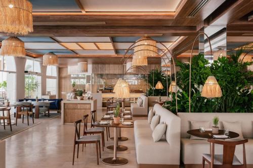 a restaurant with tables and chairs and potted plants at ME Marbella by Meliá in Marbella