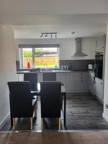 a kitchen with a table and chairs and a sink at Central 2-bedroom bunglow with double sofa bed in Carnoustie