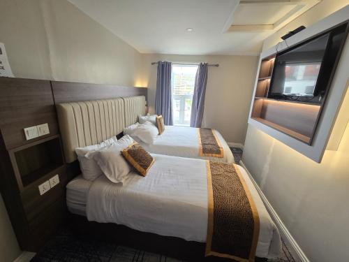 a hotel room with two beds and a television at Double bedroom studios in Dublin