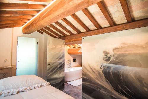 ein Schlafzimmer mit einem Bett und einem Waschbecken in einem Zimmer in der Unterkunft Vecchio Forno Only Adult, Luxury, History, Comfort in Fiorenzuola di Focara