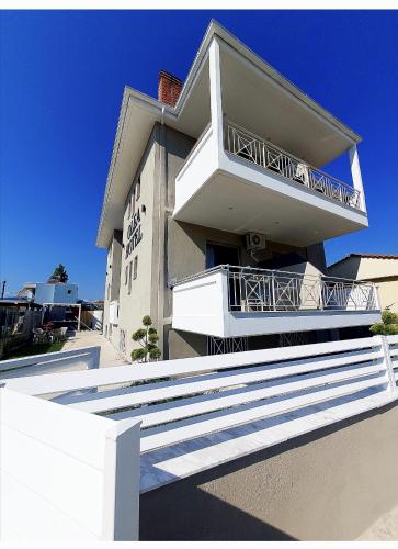 a building with a balcony and stairs in front of it at Olea Luxury Suites in Asprovalta