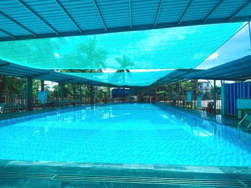 une grande piscine avec un auvent bleu dans l'établissement May Garden Homestay Ninh Bình, à Phúc Trì