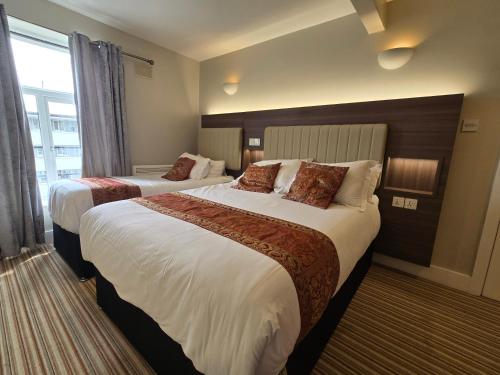 a hotel room with two beds and a window at KGT House in Dublin