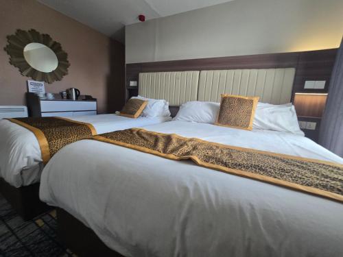 a hotel room with two large beds with a mirror at KGT House in Dublin