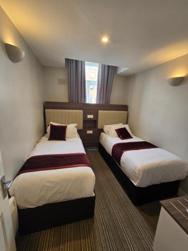 a hotel room with two beds and a window at KGT House in Dublin