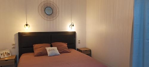 ein Schlafzimmer mit einem Bett mit zwei Lampen an der Wand in der Unterkunft Maison de vacances en plein cœur de Châtelaillon-Plage in Châtelaillon-Plage