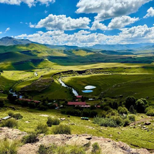 a view of a valley with a farm in a field at Tsoelike River Lodge in Sehlabathebe