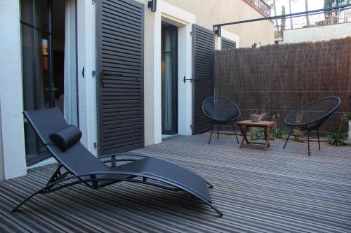 a chair on a patio with two chairs and a table at Hotel Pont Levis - Franck Putelat in Carcassonne