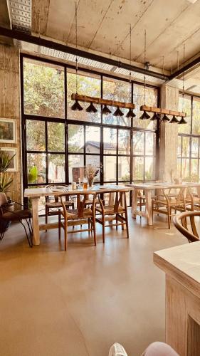 a large room with tables and chairs and windows at The Iskemleci Guest House in North Nicosia