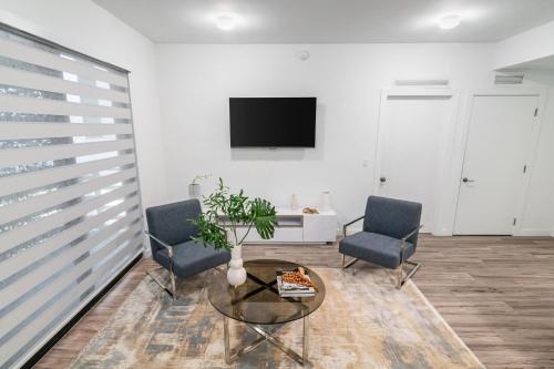 a living room with two chairs and a table and a tv at 2BR Miami Condo - Near Marina & Attractions in Miami