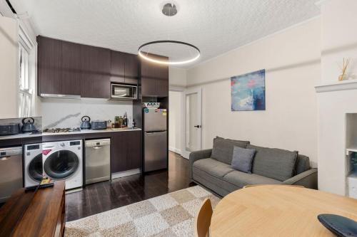 a living room with a couch and a kitchen at Millers Point Retreat 5 Min Walk to Barangaroo in Sydney