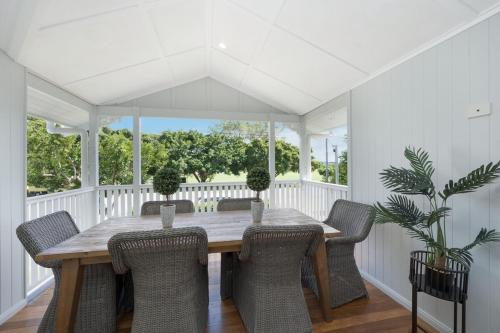 a dining room with a wooden table and chairs at Grand 4BR Queenslander on Harold Sleeps 7 in North Ward