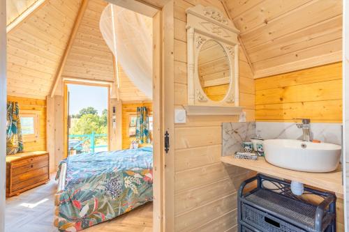 a bathroom with a sink and a bed in a room at Les Philous Gourmands in Sevremont