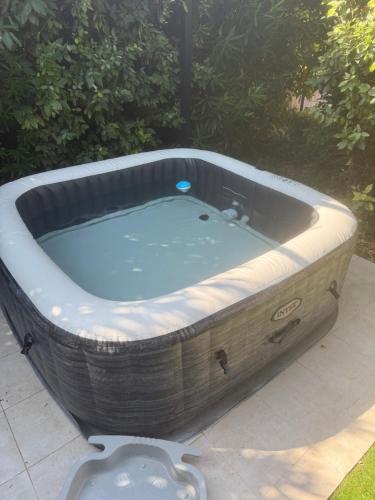 a jacuzzi tub sitting on a patio at Mazet des Orchidées - Gîte 4 personnes 50 m2 - Jardin, spa privé - indépendant - stationnement privé in Servian