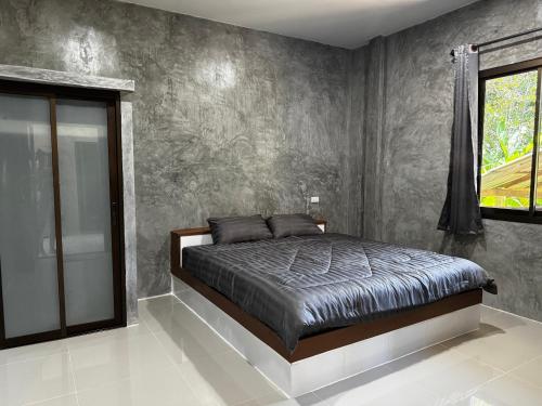 a bedroom with a bed and a window at Bantai Hideaway - House 1 in Baan Tai