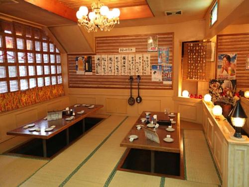 a dining room with two tables and a chandelier at Okinawa Sunplaza Hotel in Naha