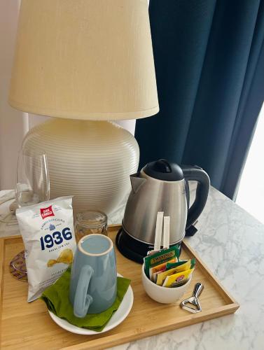 a table with a tea pot and a tray of food at Art Hotel Pietrasanta in Pietrasanta