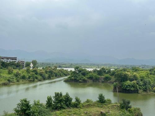 a river with trees on the side of it at Kalyan luxury rooms in Garudeshwar