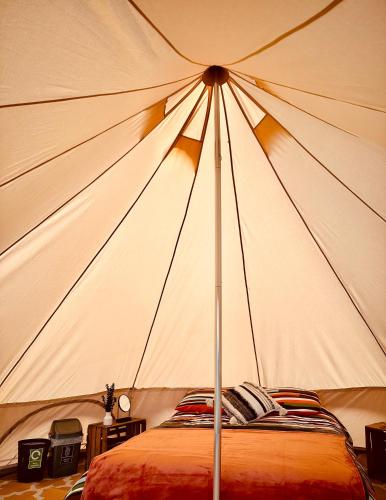 a large tent with a bed in it at Lakeside Glamping Firecrest in Saint Columb Major