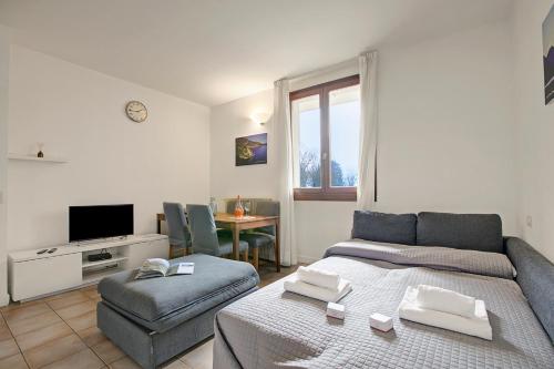 a living room with a couch and a table at Budget Village Apartments - Porto Letizia in Porlezza