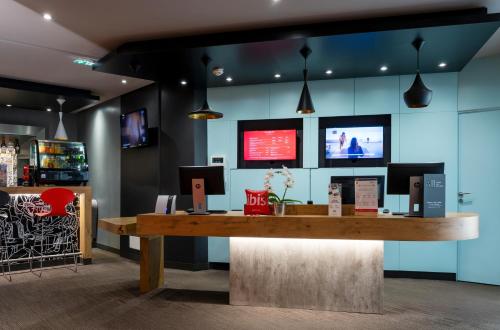 a reception desk in a room with a tv at ibis Nancy Centre Gare et Congres in Nancy