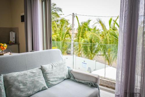 a living room with a couch and a large window at Bois Mapou Self Catering Apartments Unit 203 in Rivière Noire