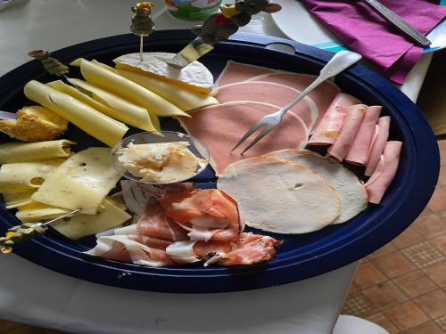 a plate of food with meats and cheese on a table at Wald-Ferienwohnung in Wildemann in Wildemann