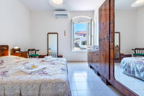 1 dormitorio con 2 camas, vestidor y ventana en GuestHost - Tabarka's House, en Carloforte