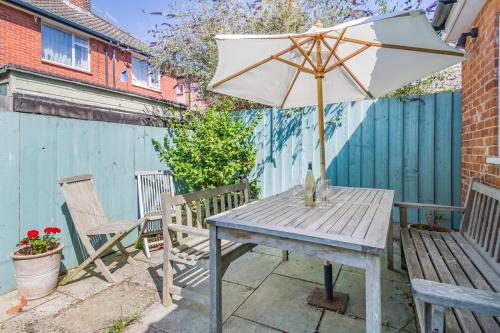 a wooden table with an umbrella and two chairs at 3 Bed in Aldeburgh oc-f32700 in Aldeburgh
